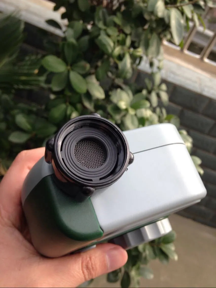 Green digital programmable water timer for garden hose with copper connector and LCD screen.