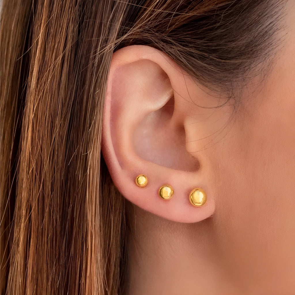 Stainless steel 18K gold ball stud earrings in round geometric design on simple stud posts.