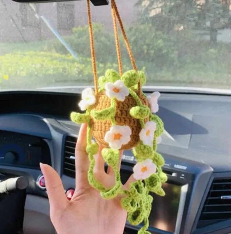 Green and white knitted wool car plant decoration basket with white hanging cord.