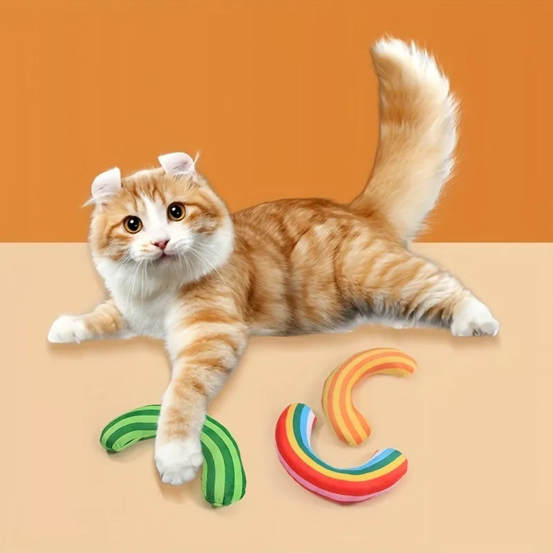 Green, rainbow, and yellow striped cat pillow and noise toy set on a white background