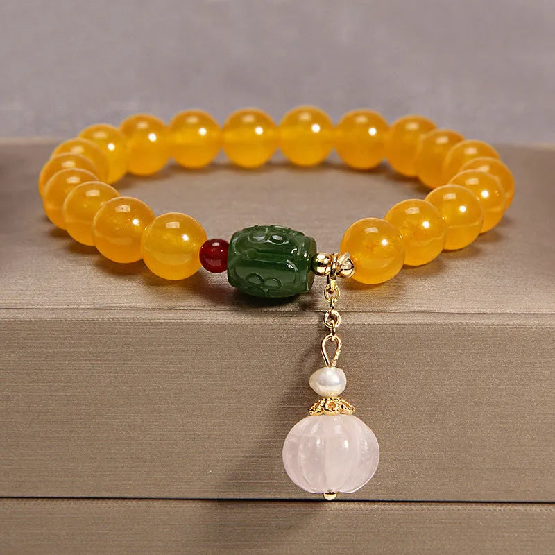 Adjustable khaki bracelet with large yellow agate bead on gold silk cord.