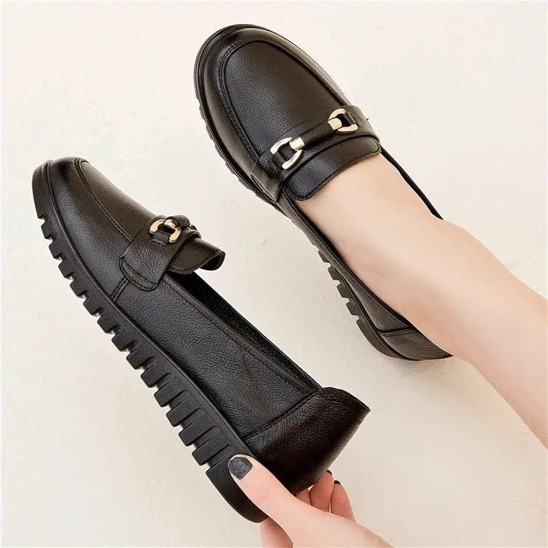 Black soft leather women's pumps with a round toe, low flat heel, and rubber sole.