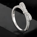 Silver plated bow-shaped ring with clear rhinestone crystal decoration on a model finger