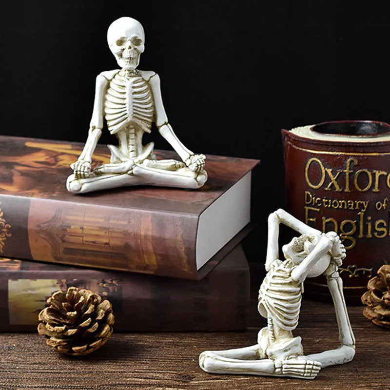 Detailed resin Halloween ornament of a yoga-posing skeleton skull on a desktop.
