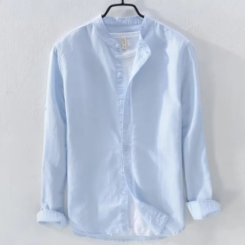 Man's loose fitting long sleeve linen shirt in a solid colour on a hanger.