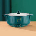 Stainless steel electric hot pot with non-stick coating and integrated heating base.