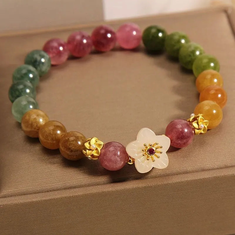 Natural tourmaline bracelet with flower and Fu charms on silver-tone electroplated brass.