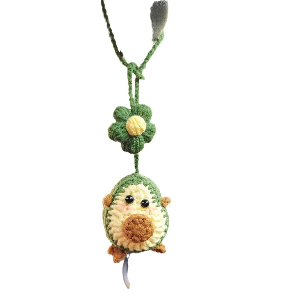 Handmade crocheted avocado with rainbow flower car pendant in wool yarn.