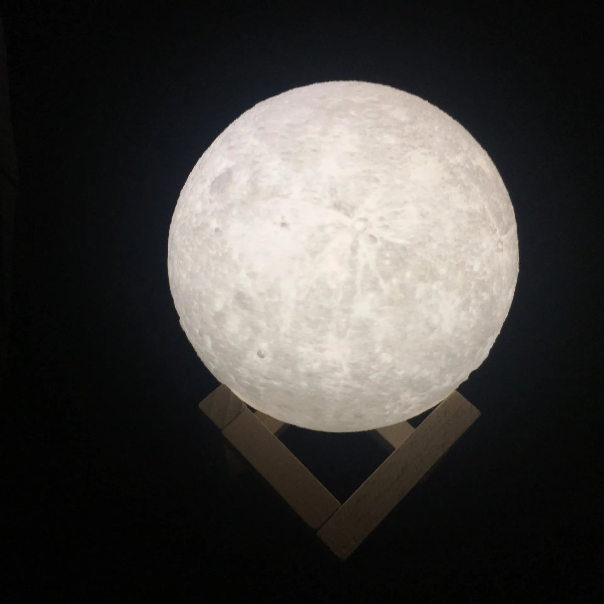 3D printed moon light lamp on wooden stand with detailed lunar surface, showing touch ring at base.