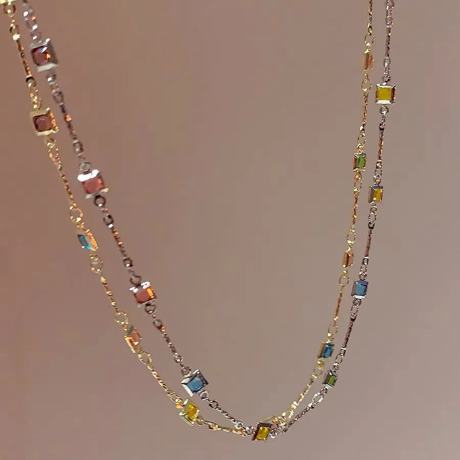 Square colour geometric clavicle chain necklace with artificial crystal details in gold tone.