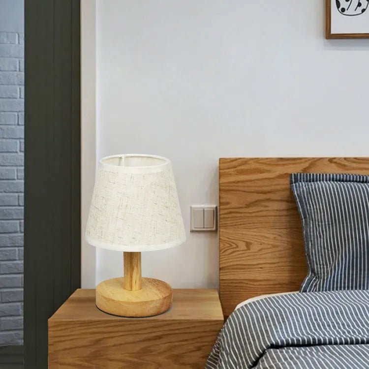 Korean style table lamp with white linen shade and bamboo holder on wooden table