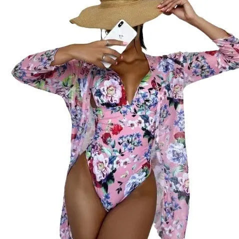 Women's floral patterned bikini three-piece set with a matching coat on a hanger