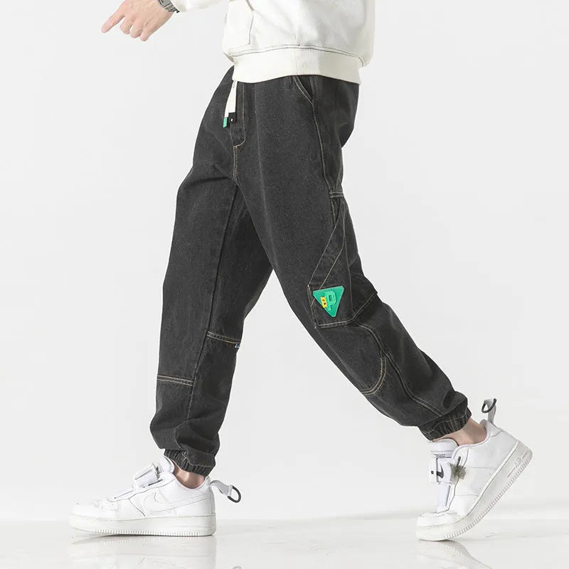 Men's loose-fit tapered cotton trousers in black, shown on a model