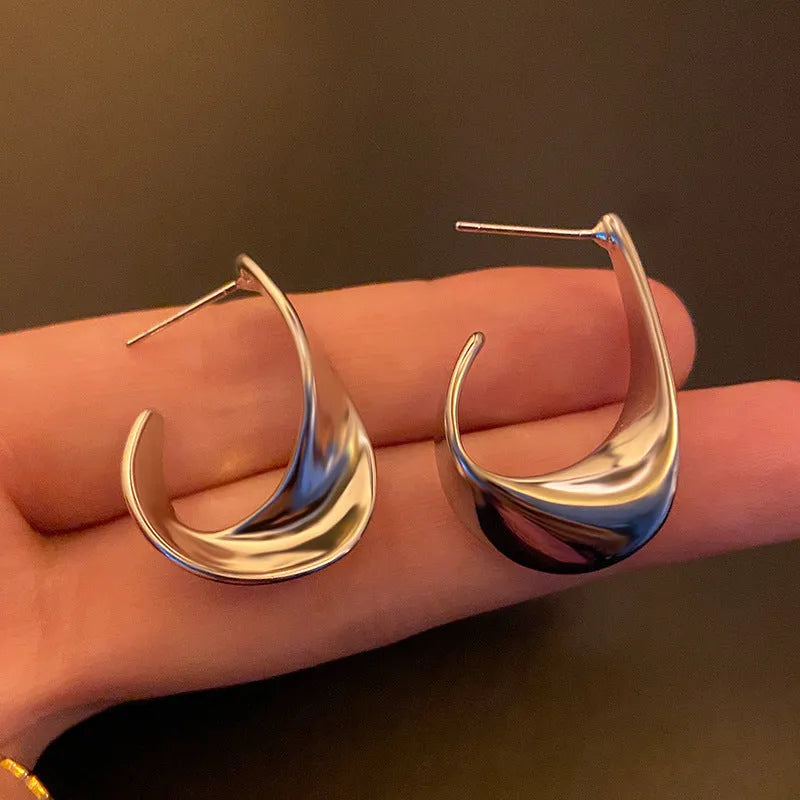 Metal twisted geometric earrings with round elements in gold or silver finish