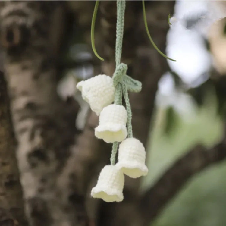 Green and white knitted wool car plant decoration basket with white hanging cord.