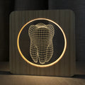 Wood-coloured tooth-shaped acrylic night lamp with USB cable on a surface.