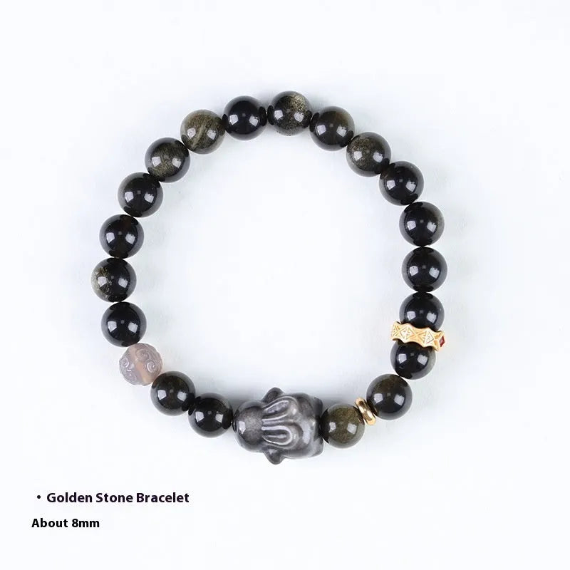 Handmade lying rabbit obsidian bracelet with grey agate beads and brass details on a wrist.