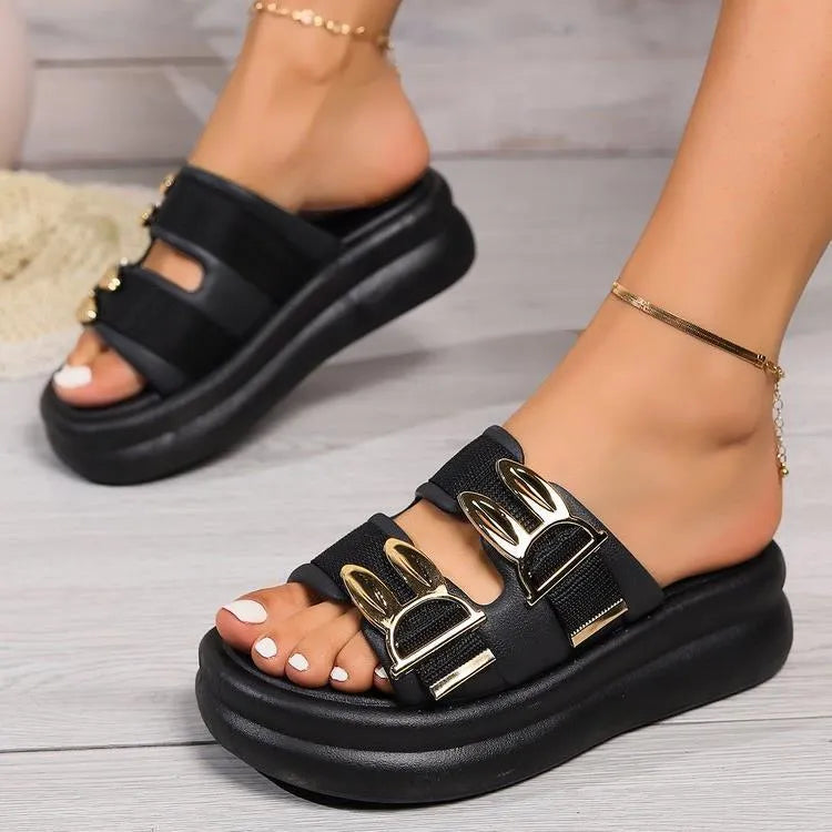 Women's apricot suede slippers with a thick, soft rubber sole on a wooden floor.