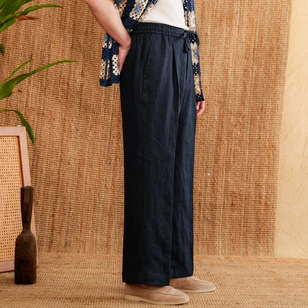Linen straight-leg trousers in greige with an elasticated high waistband on a neutral background.