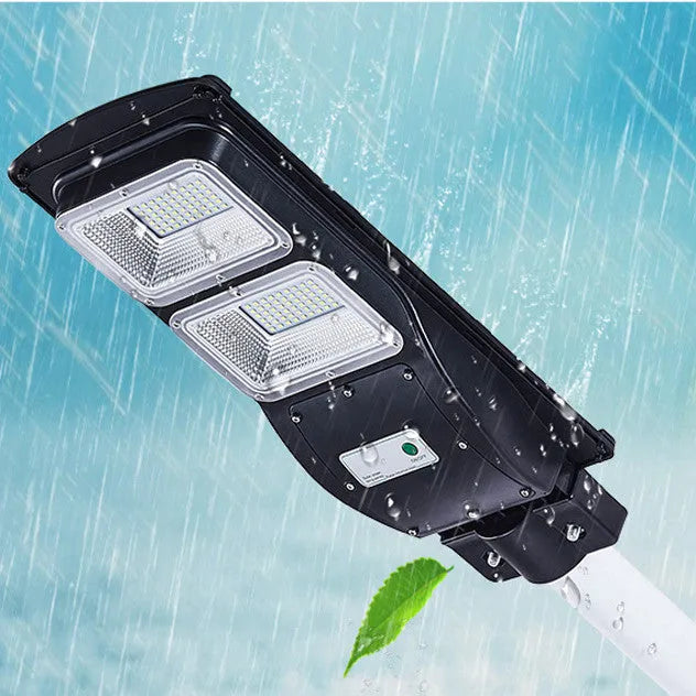 Integrated solar street light with aluminium housing and solar panel, showing remote control and outdoor installation