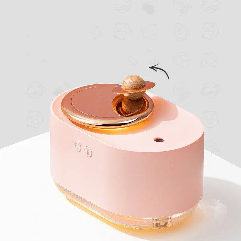 Green rotating planet USB humidifier with night light on a wooden desk