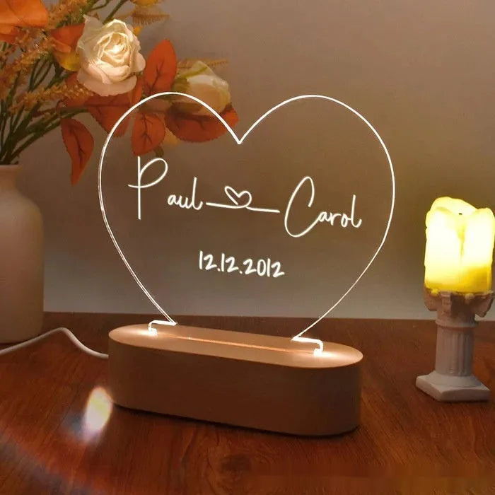 Personalised acrylic night light showing illuminated custom names and date on a transparent panel.