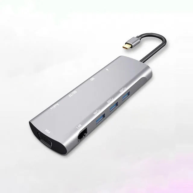Grey aluminium USB-C docking station with HDMI, VGA, and USB 3.0 ports.