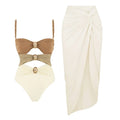 Women's solid colour one-piece swimsuit with gold buttons and a matching detachable skirt.
