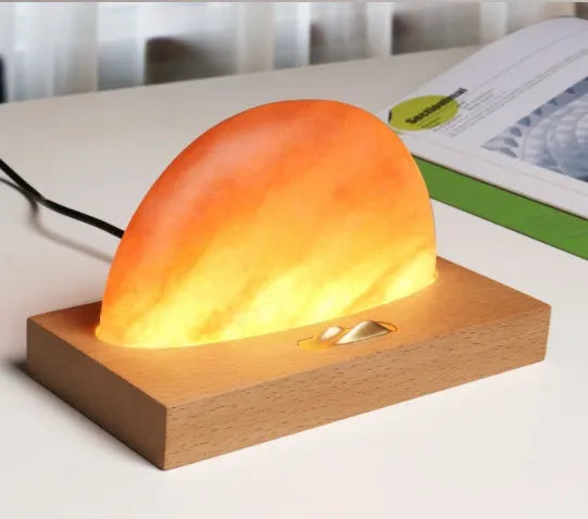 Natural crystal salt lamp on a beech wood base with integrated wireless phone charging pad.