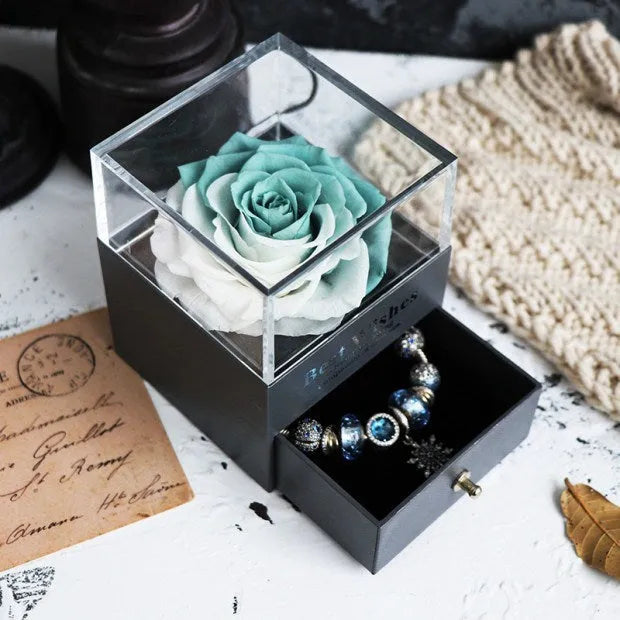 Glass eternal flower jewellery box with preserved roses and carnations inside measuring 8.5cm square