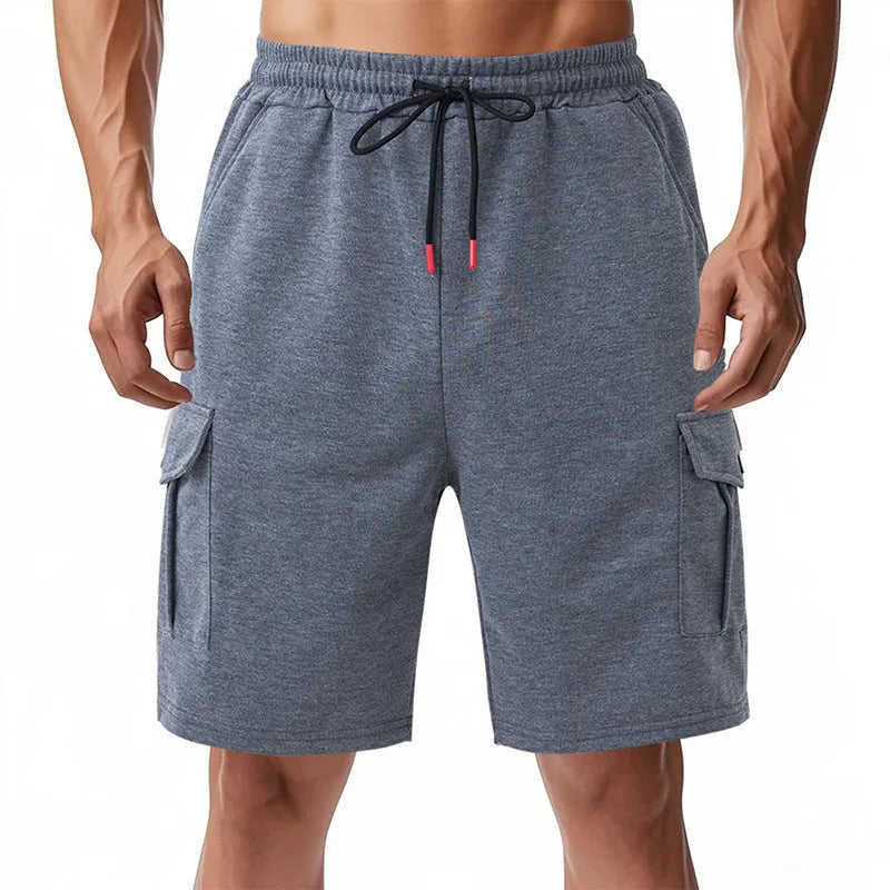 Man wearing light grey loose-fit cargo shorts made from textured towel fabric with multiple pockets.