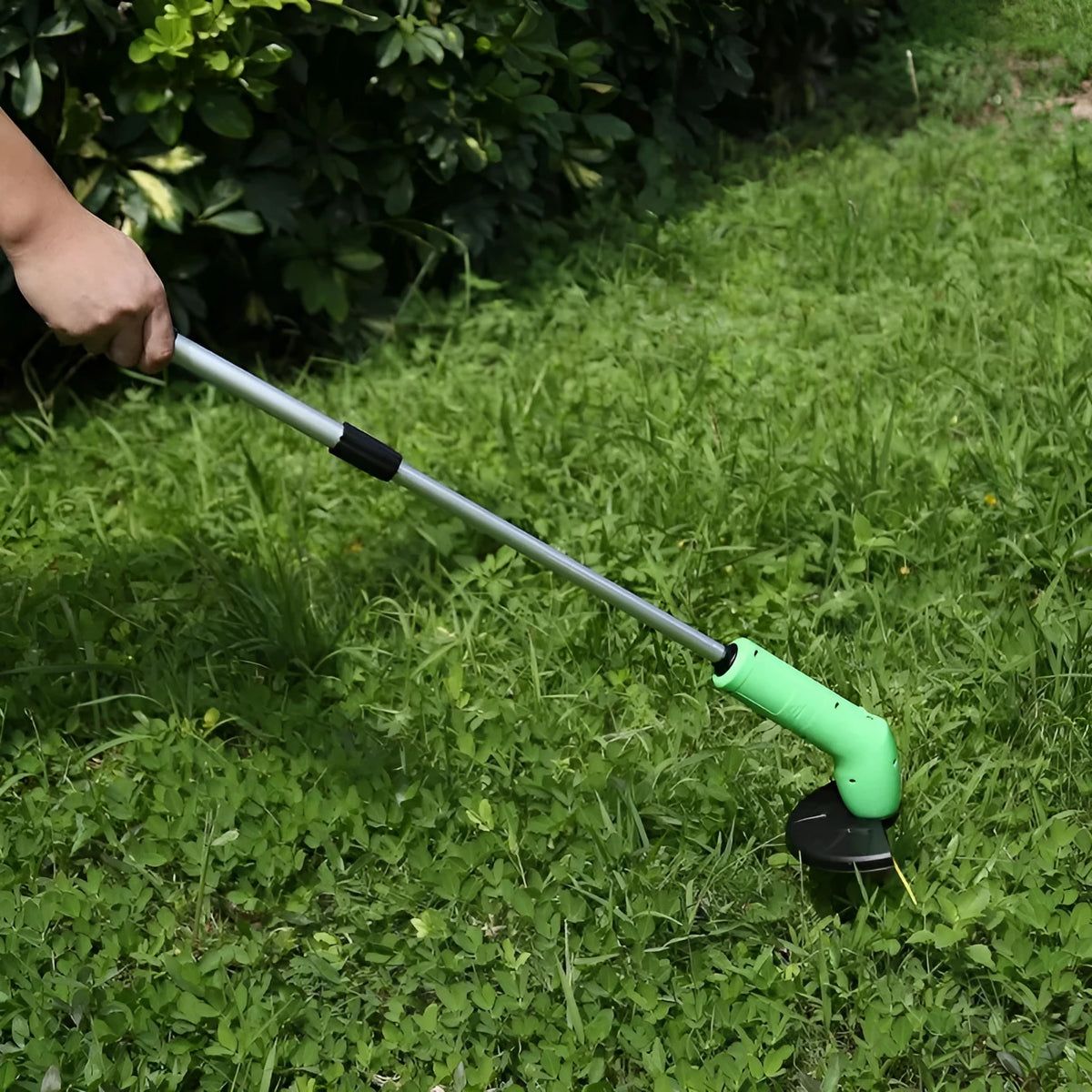 Cordless Zip Trim handheld lawn mower and weed trimmer with extension pole and debris shield.