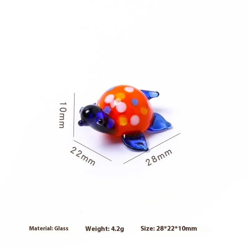 Glass geometric turtle ornament in blue head with blue shell colour variation on wooden desktop