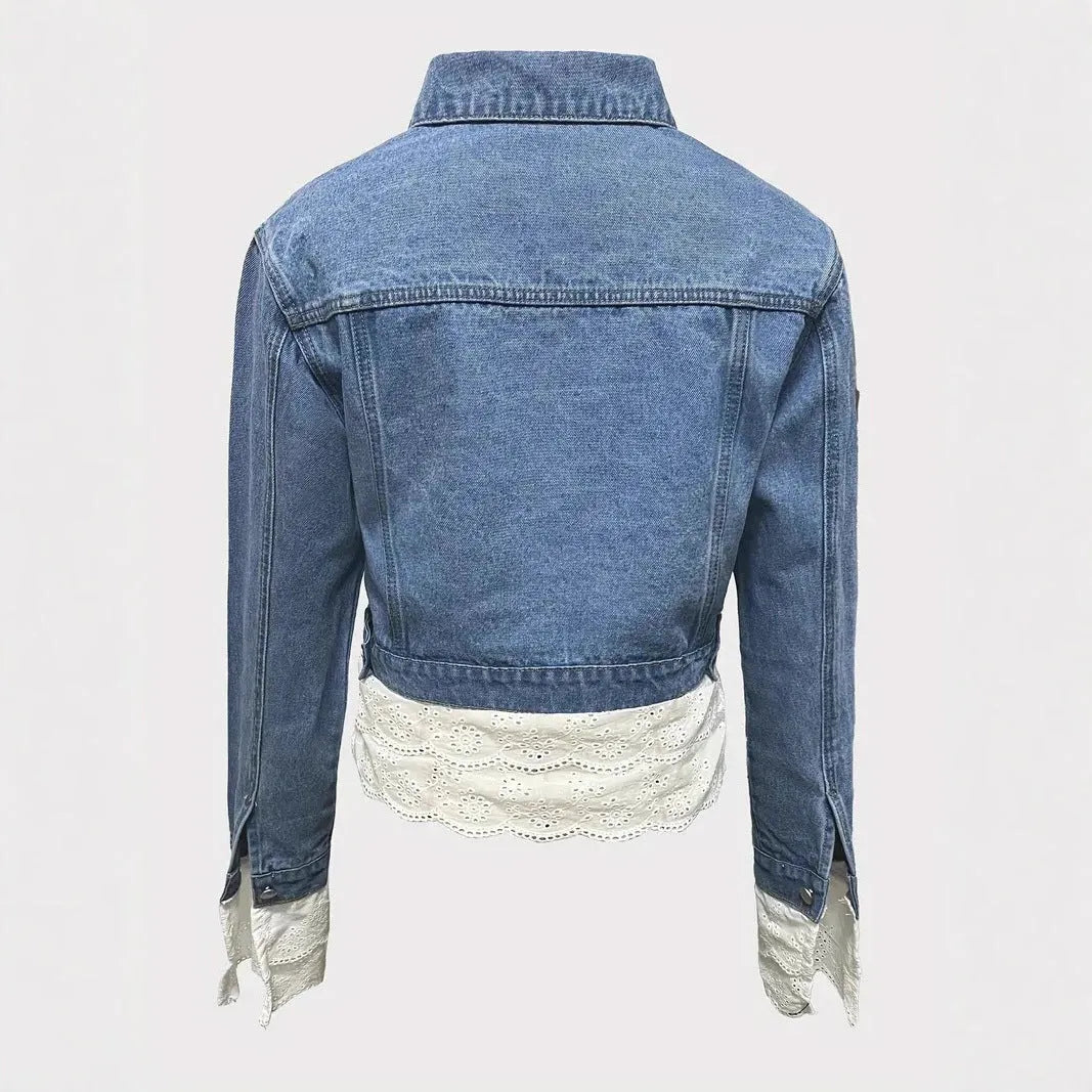 Blue women's denim jacket with lace stitching on the front, shown on a hanger.