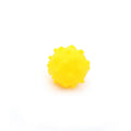 Set of four brightly coloured spiked squeaky dog balls on a blue background