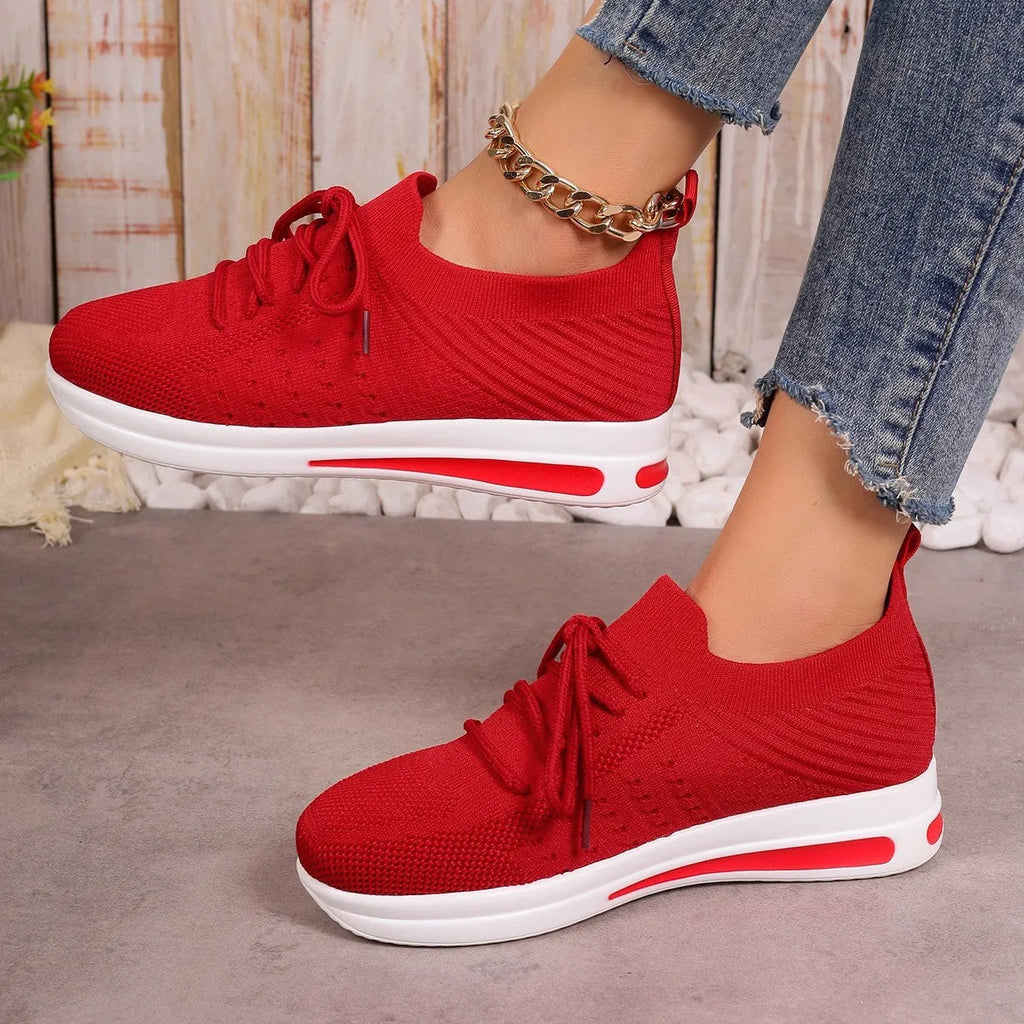 Women's low-top casual sneakers in black, blue, and red with a fly-knit style PU upper and lace-up front.