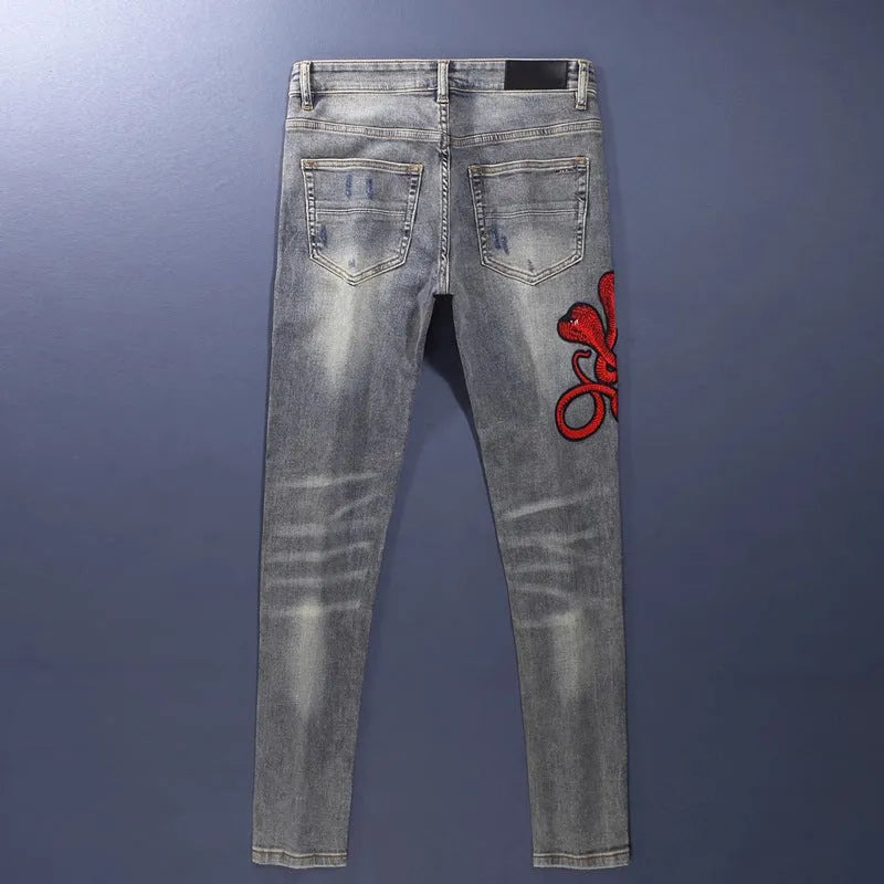 Men's washed-out slim fit jeans with patch detailing and embroidered branding on micro-elastic cotton