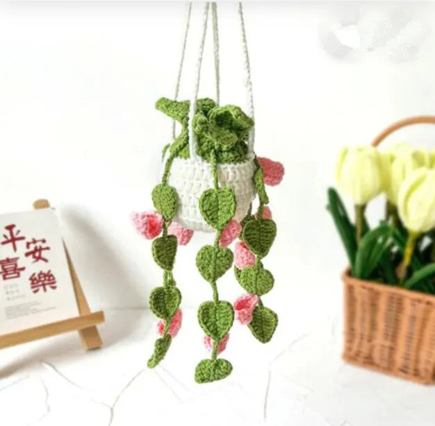 Green and white knitted wool car plant decoration basket with white hanging cord.