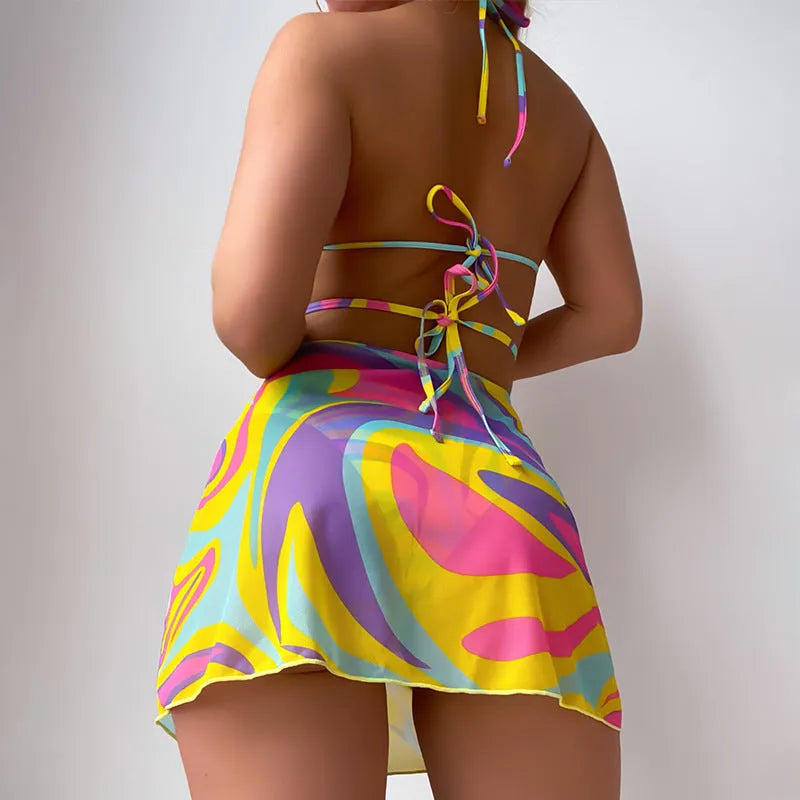 Yellow striped halter lace-up swimsuit for women with matching skirt and shorts.