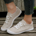 Women's creamy white beige fabric low-top casual sneakers with a rubber sole on a plain background.
