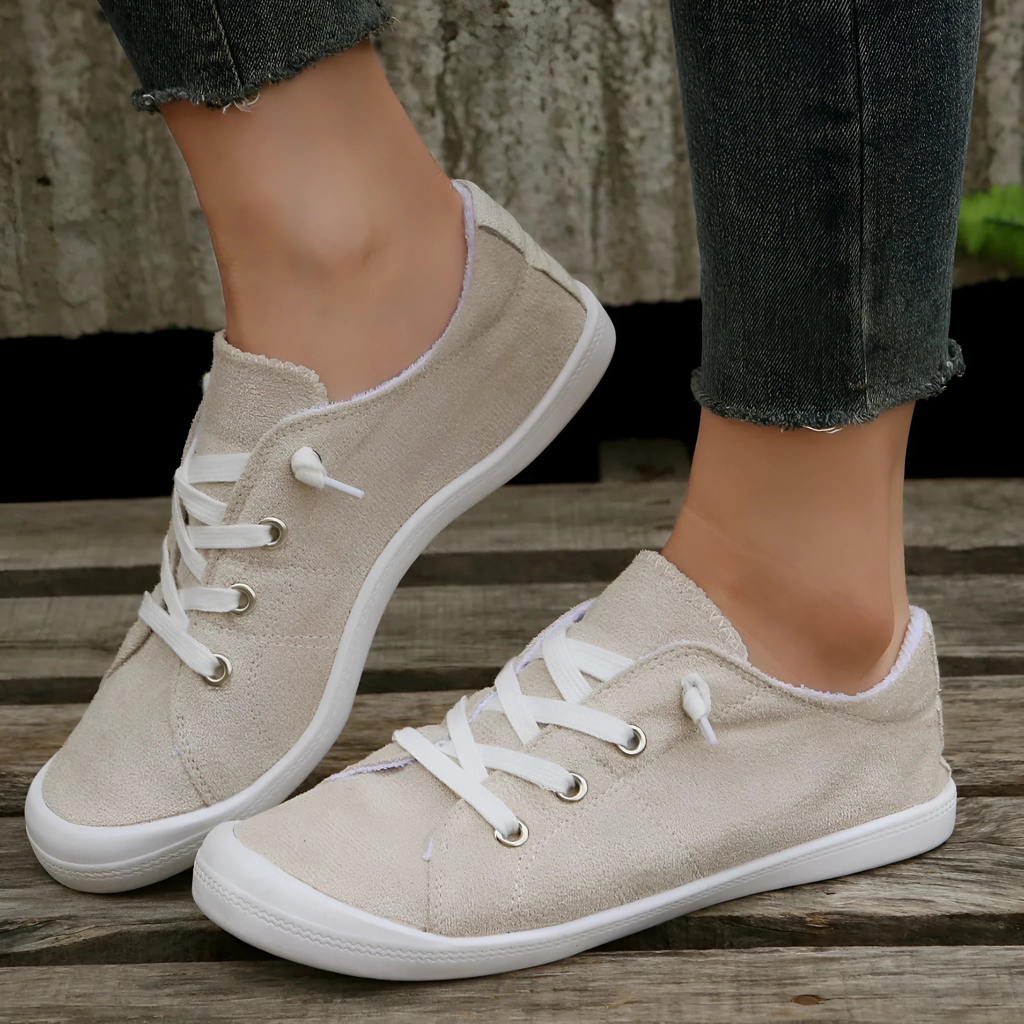 Women's creamy white beige fabric low-top casual sneakers with a rubber sole on a plain background.