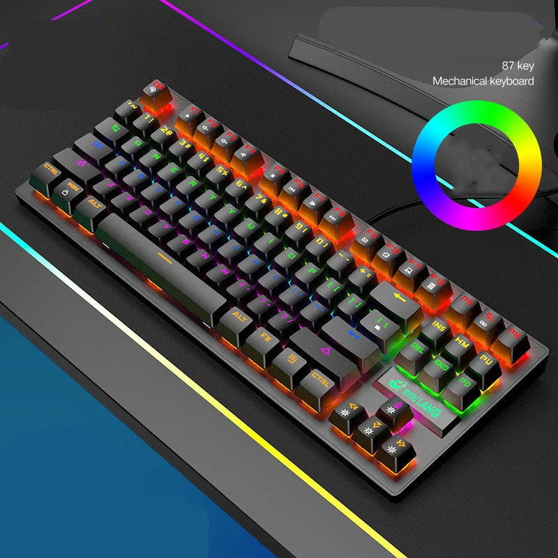 Compact mechanical gaming keyboard with RGB lighting next to laptop