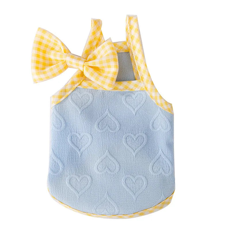 Small dog wearing blue elastic vest with heart pattern and bow suspenders