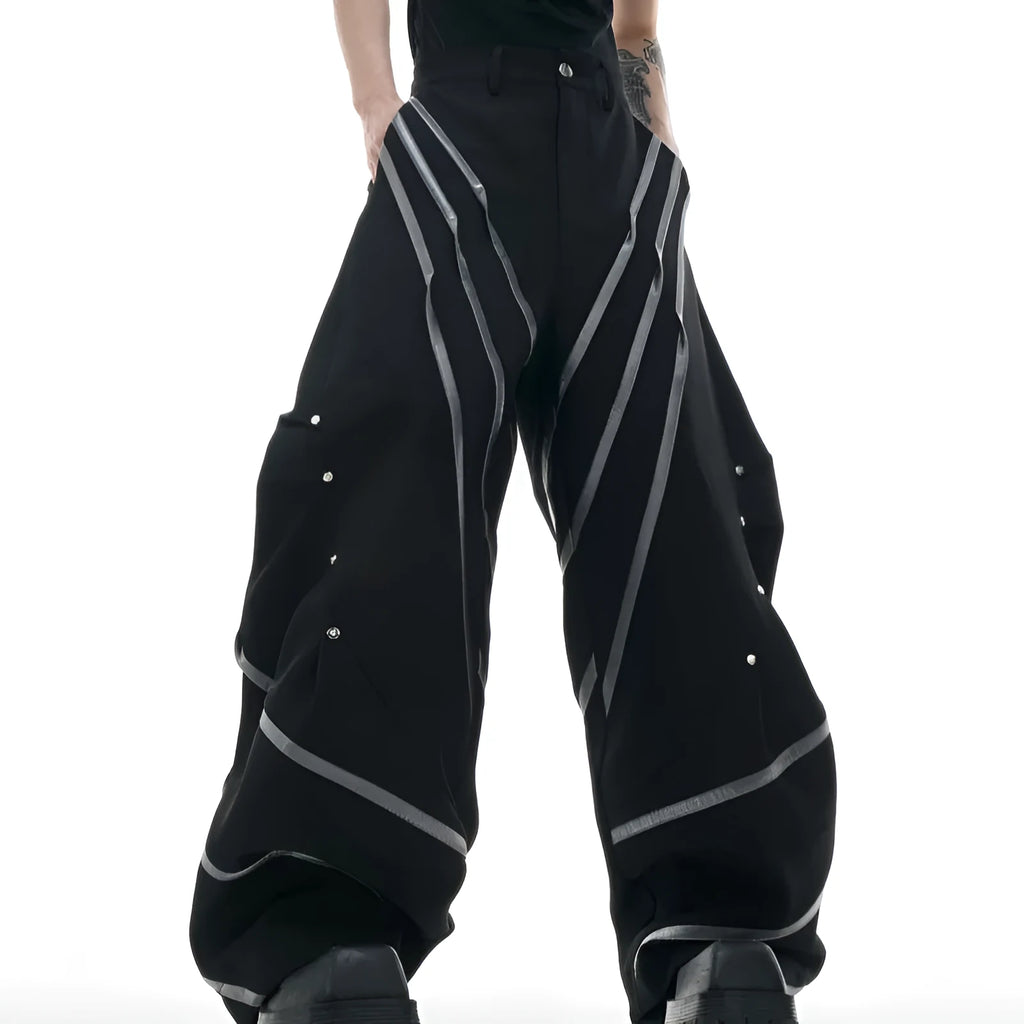 Men's black trousers with silver metal striped rivet details and pleated front.