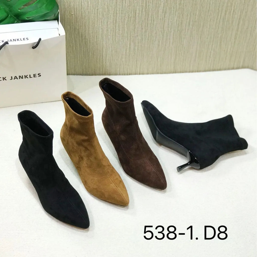 Black pointed toe women's ankle boots with stiletto heel on a plain background