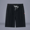 Man wearing solid colour cotton linen cropped trousers with a drawstring waist in a casual setting.