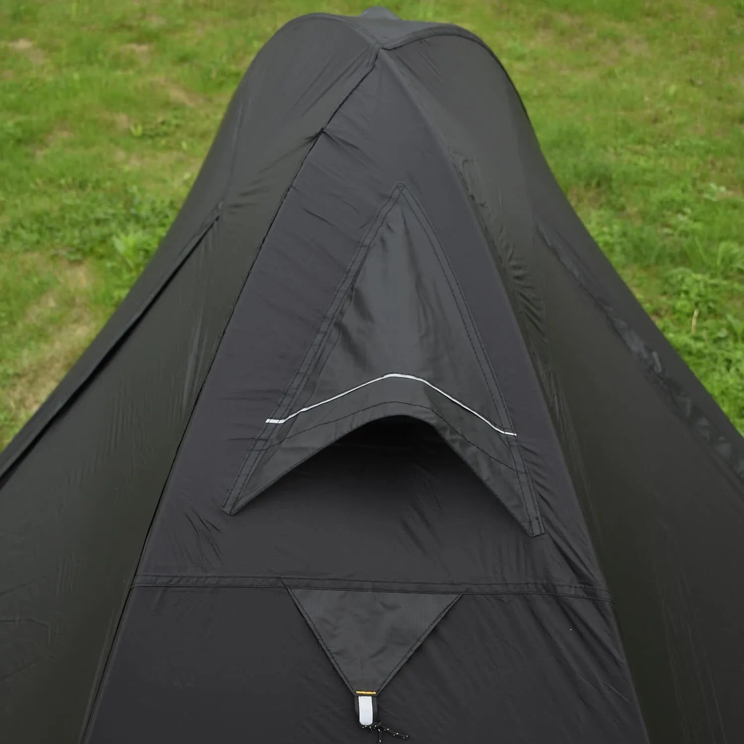 Single person orange hiking tent with aluminium poles pitched in outdoor setting
