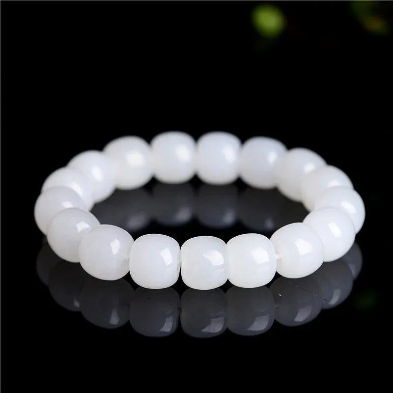 White Hetian jade barrel bead bracelet for men and women on a neutral background.