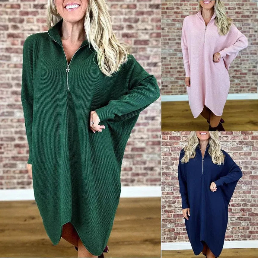 Dark green loose knitted women's dress with full front zipper and raglan sleeves on a hanger.