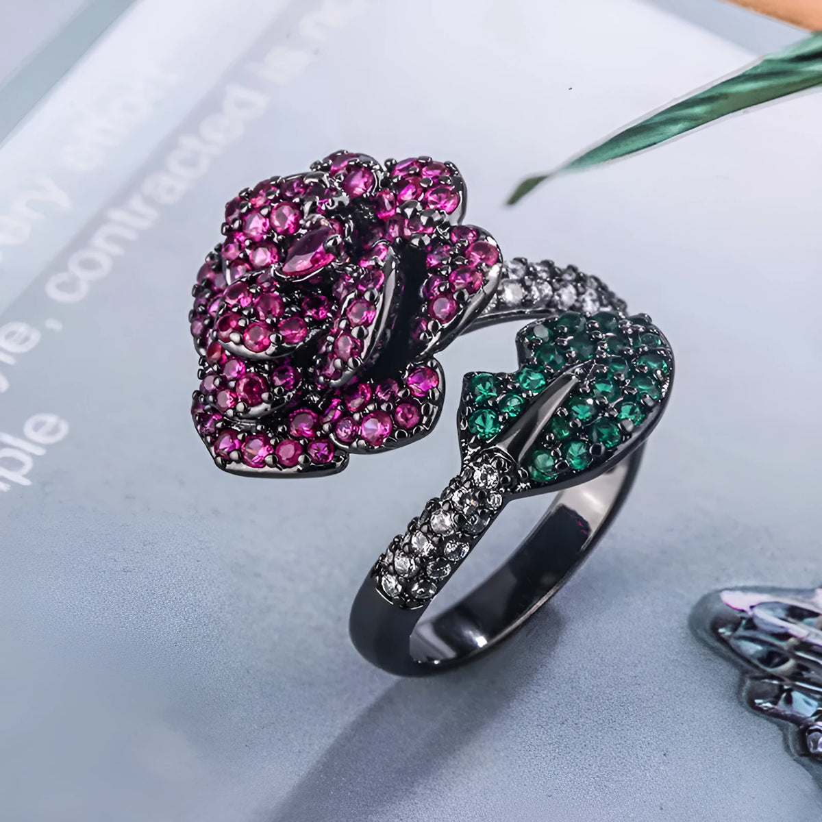 Gold-plated copper women's ring with geometric flower design and simulated red corundum in black gold colour.